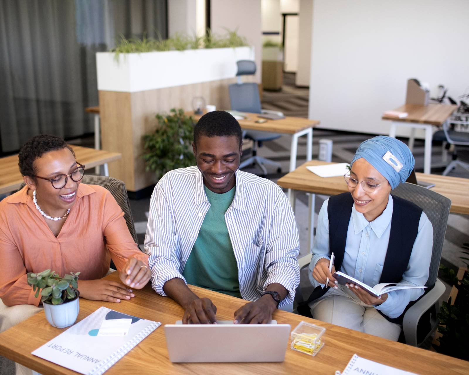 Diverse changemakers collaborating around a laptop